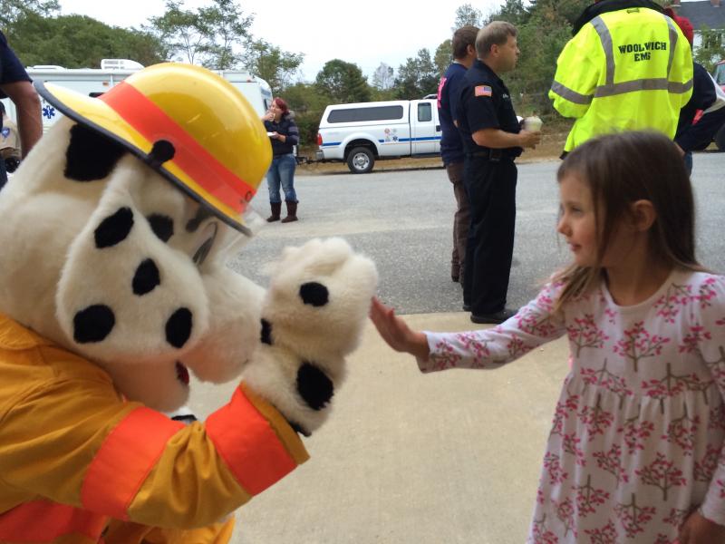 At Dresden Fire Department’s open house Oct. 1, Sparky exchanges high fives with Skylynn Garnett, 4, of Dresden. SUSAN JOHNS/Wiscasset Newspaper Skylynn Garnett