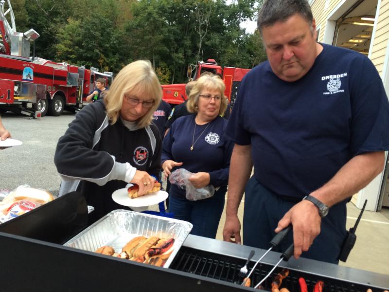 Sonia Pearson, left, of Wiscasset picks up a hot dog prepared by Dresden Fire Department member Pat Theriault and Assistant Chief Ron Theriault at the department’s open house October 1. SUSAN JOHNS/Wiscasset Newspaper Sonia Pearson, Pat Theriaut, Ron Theriault