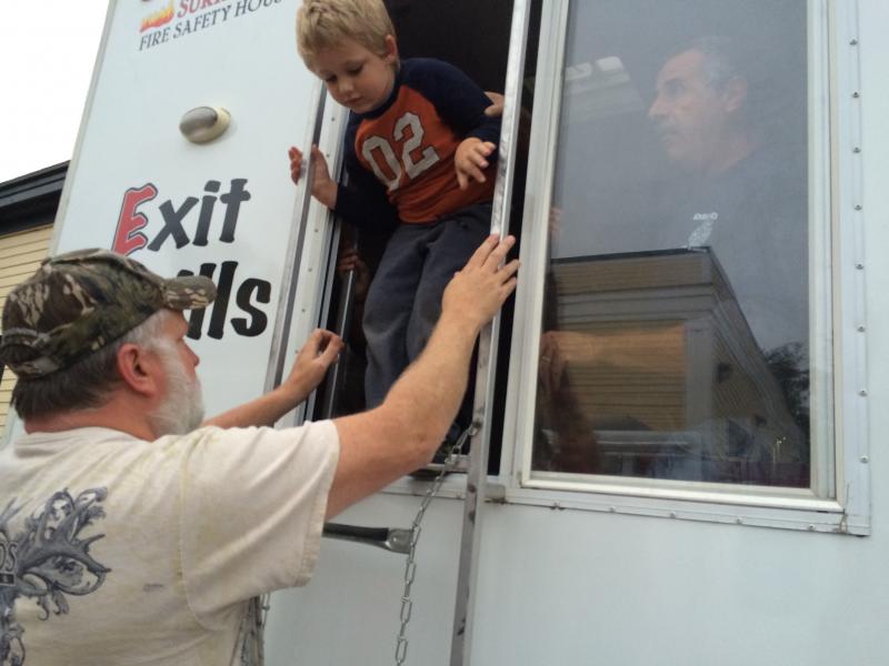 Wiscasset’s Tim Pearson helps grandson Nelson Jones down from a window after Jones’ trip through a series of smoky rooms at Dresden Fire Department’s open house Oct. 1. SUSAN JOHNS/Wiscasset Newspaper Tim Pearson, Nelson Jones