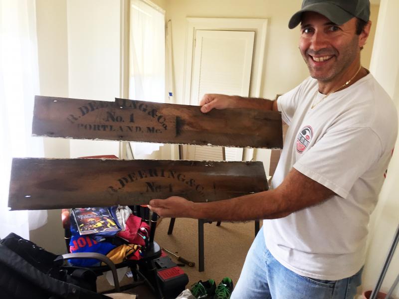 Anthony Vitti holds one of the Tiny House’s original clapboards, from Deering Lumber. SUZI THAYER/Boothbay Register