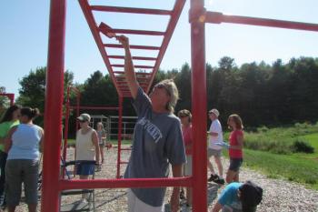 Wiscasset Primary School first-grade teacher Tracy Jackson joins fellow staff, students and parents in giving the school playground a fresh coat of paint. Courtesy Wiscasset Primary School