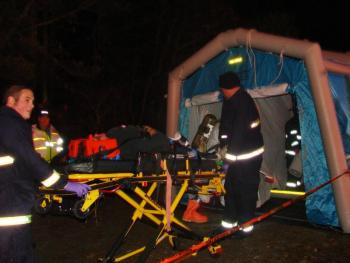 Emergency workers take a "patient" toward a decontamination tent along Route 27 in Wiscasset, as part of a large disaster drill that involved several agencies from around the region. The drill scenario involved an accident between an oil truck and a bus taking people to a shelter when power was out in a winter storm. SUSAN JOHNS/Wiscasset Newspaper