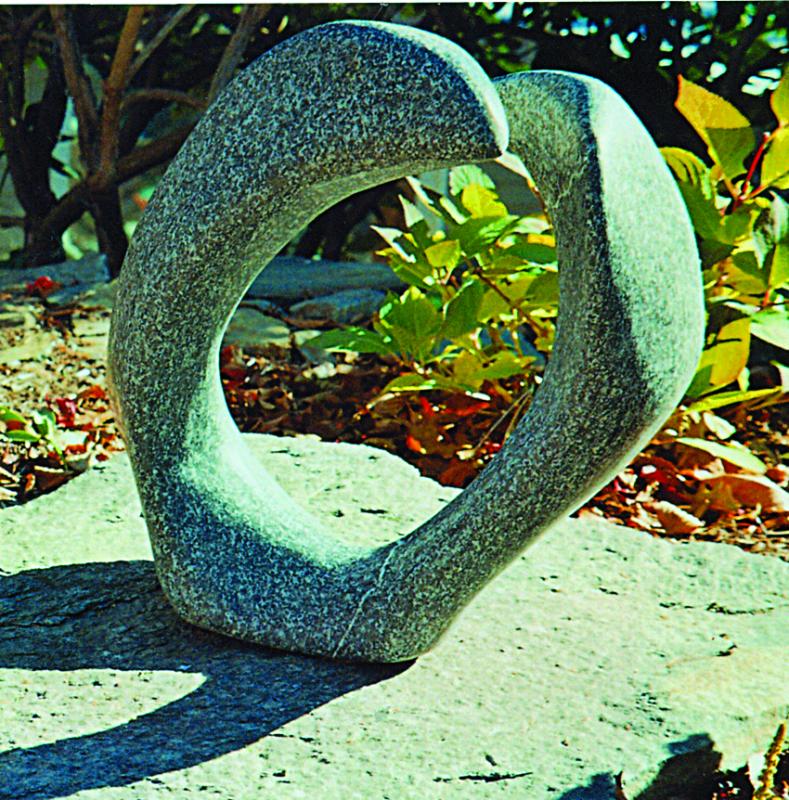One of Gerry Plummer's granite sculptures on display throughout the perennial flower gardens and the stone walls leading down to the sea. Below, Jennifer and Brian Cook of Hope, R.I., were the winners of a Carlton Plummer painting at the Plummer Gallery and Gardens open house on August 5. The Cooks have been summering at a cottage close to the gallery. Courtesy of Plummer Gallery