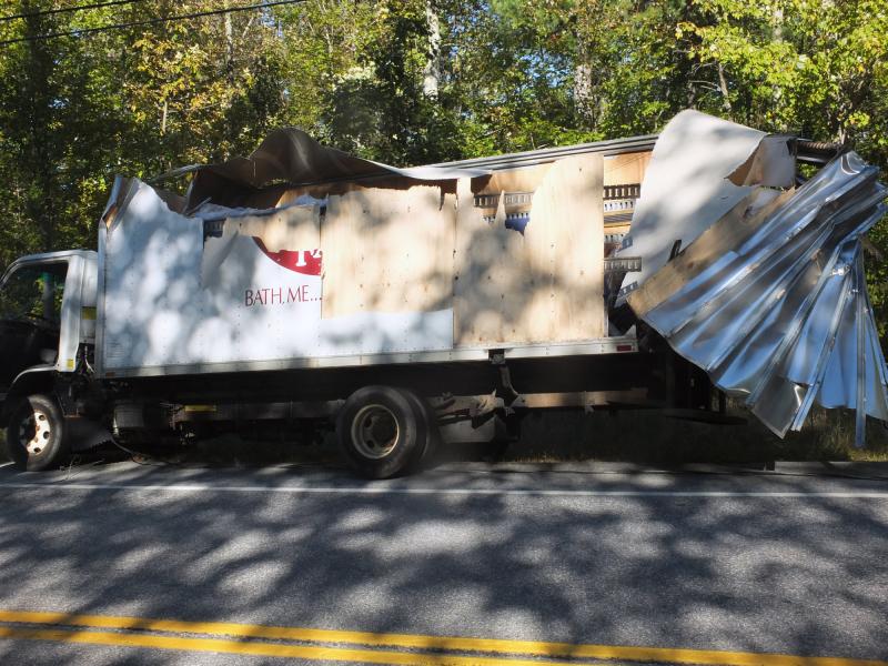 This Country Farm Furniture truck sustained heavy damage from the downed wires of another accident on Route 27 in Dresden. Below, emergency personnel begin working to get the driver out of the overturned truck. KATHY ONORATO/Wiscasset Newspaper This Country Farm Furniture truck sustained heavy damage from the downed wires of another accident on Route 27 in Dresden. KATHY ONORATO/Wiscasset Newspaper