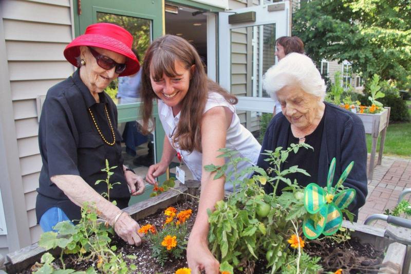 Marie Callnan (on left), Gregory Wing Activities Director Jerie Phinney, and Veula Reed (on right) work in one of the raised bed gardens outside the Gregory Wing at St. Andrews Village. A new garden made possible by the St. Andrews Hospital Auxiliary will make it easier for more residents to enjoy the outdoors in an unstructured but secure atmosphere. The new garden features a walkway, patio and wooden fence. Courtesy of Lincoln County Healthcare Marie Callnan (on left), Gregory Wing Activities Director Jerie Phinney, and Veula Reed (on right) work in one of the raised bed gardens outside the Gregory Wing at St. Andrews Village. A new garden made possible by the St. Andrews Hospital Auxiliary will make it easier for more residents to enjoy the outdoors in an unstructured but secure atmosphere. The new garden features a walkway, patio and wooden fence. Courtesy of Lincoln County Healthcare