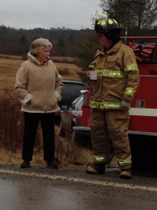 Alna firefighter Jeff Averill, right, has some coffee that Kitty Lipp brought out to emergency workers at the scene. SUSAN JOHNS/Wiscasset Newspaper Alna firefighter Jeff Averill, right, has some coffee that Kitty Lipp brought out to emergency workers at the scene. SUSAN JOHNS/Wiscasset Newspaper