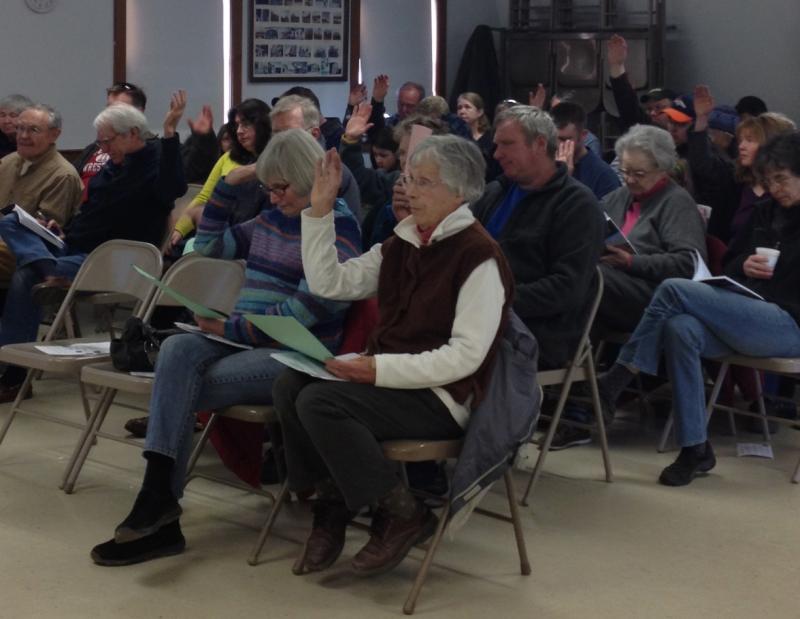 Alna voters make their wishes known during town meeting at the fire station. Below: Alna Assistant Fire Chief Roger Whitney discusses the department’s regulatory requirements, as residents debate fire officials’ raises at the annual town meeting March 16. SUSAN JOHNS/Wiscasset Newspaper Alna voters make their wishes known during town meeting at the fire station. SUSAN JOHNS/Wiscasset Newspaper