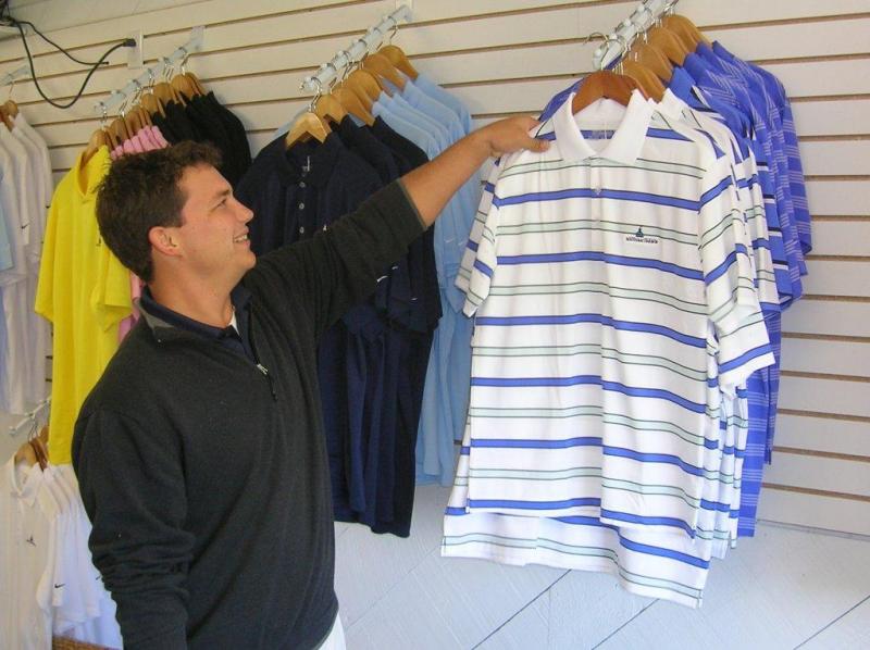 Assistant pro Raynor Lynn hangs up brightly colored golf shirts as he restocks the pro shop with new merchandise. JOE GELARDEN/Boothbay Register Assistant pro Raynor Lynn hangs up brightly colored golf shirts as he restocks the pro shop with new merchandise. JOE GELARDEN/Boothbay Register