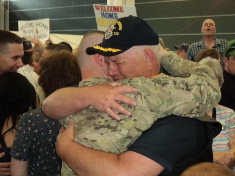 Peter Greenleaf hugs his son, Pvt. Nick Greenleaf, upon his return to Maine June 15. Below: The Greenleaf and Leighton families hold signs welcoming their soldiers home from Afghanistan; Pvt. Mason Leighton talks with his father, Micheal Leighton, and family friend, Patrick Higgins. Courtesy of Isaac Luken Peter Greenleaf hugs his son, Pvt. Nick Greenleaf, upon his return to Maine June 15. Courtesy of Isaac Luken