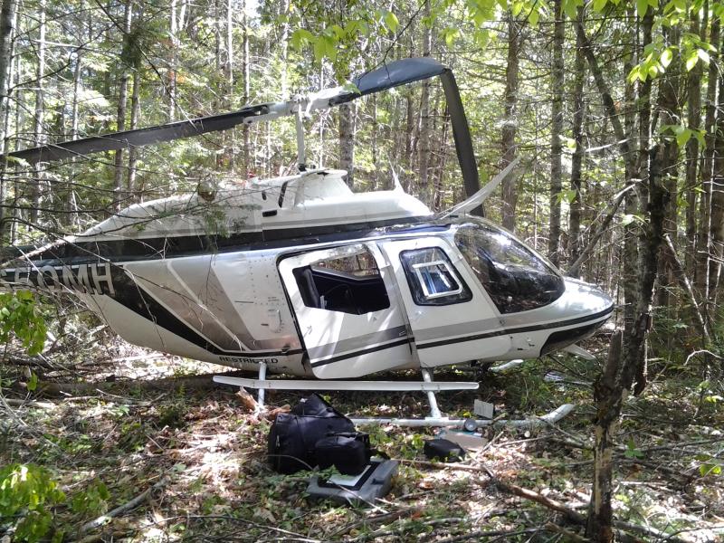 This helicopter crashed into trees off Whitefield’s East River Road, on the edge of land owned by Kathleen Woodbury. Woodbury said she found the pilot outside the helicopter, saying he was fine. Courtesy of Kathleen Woodbury helicopter crash