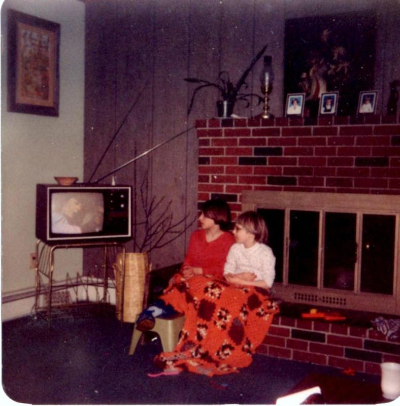 In the family living room that is now part of a newspaper office, sisters Melanie Nunan, left, and younger sister Melinda Nunan, now Melanie Kelly and Melinda Fuller, watch a television with rabbit-ear antennae. Courtesy of Melinda Fuller Melanie Kelly, Melinda Fuller