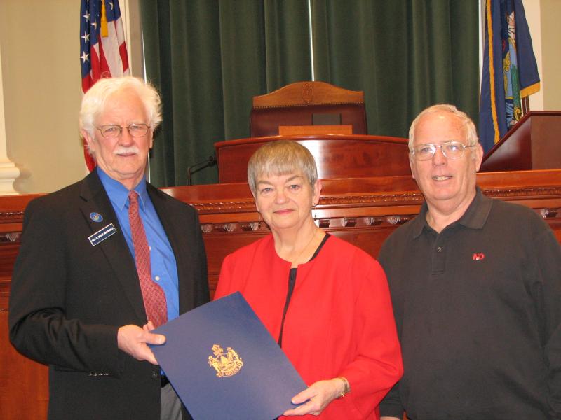 Rep. Bruce MacDonald presents Lincoln County TRIAD chairman and Boothbay Harbor resident Debbie Mullen with a special legislative sentiment in the State House in March of 2010. Mullen was joined by then TRIAD Vice Chairman Dwight Lewis of Southport. File photo
