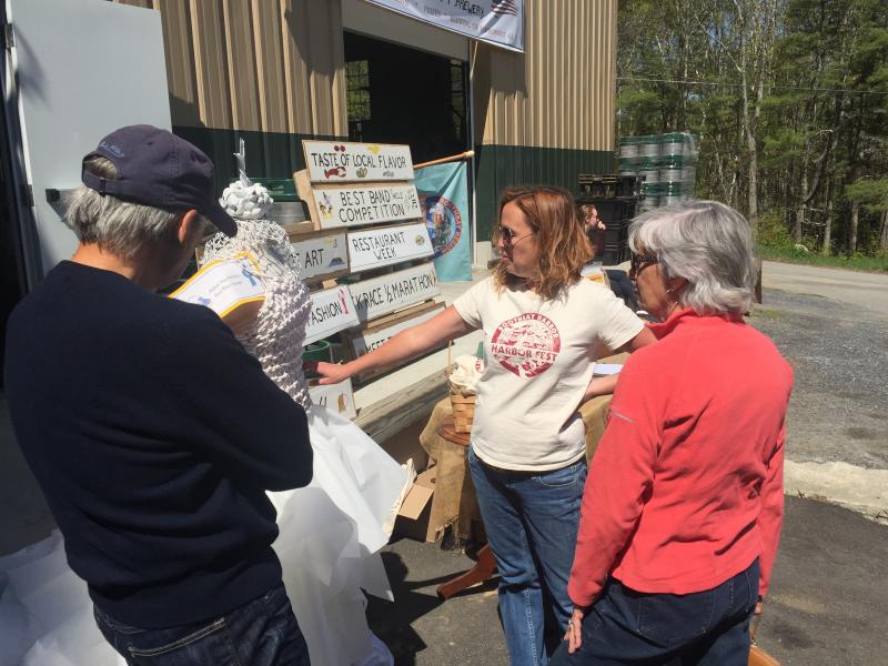Lori Reynolds talks to local visitors about what Harbor Fest is all about. KATRINA CLARK/Boothbay Register