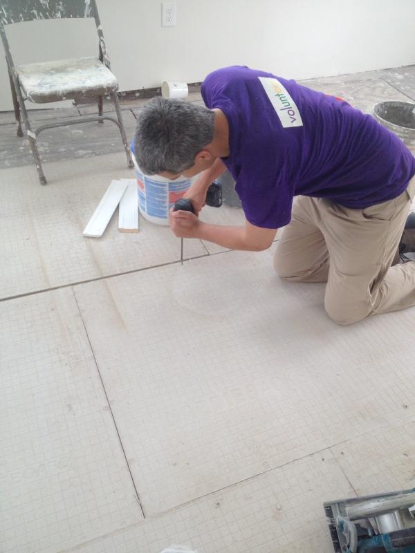 A volunteer with www.lowernine.org works on installing flooring in a new home. Courtesy of Rick Prose