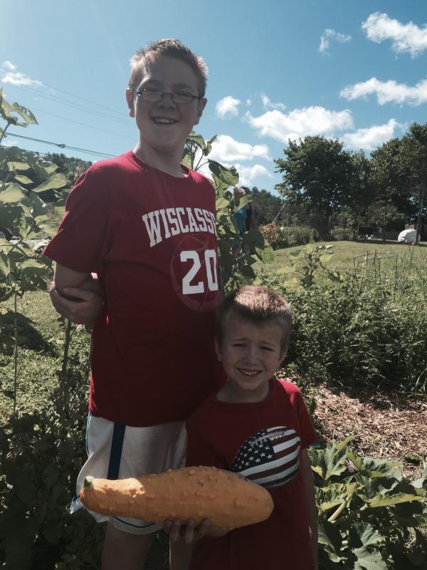 John Pray, 6, of Wiscasset, with brother Isaac Pray, 12, holds a summer squash at Morris Farm during the Aug. 6 celebration of learning for the Wiscasset School Department’s summer program. SUSAN JOHNS/Wiscasset Newspaper John Pray, Isaac Pray