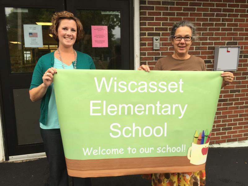 Wiscasset Superintendent of Schools Heather Wilmot, left, and Wiscasset Elementary School Principal Mona Schlein on Monday hold the sign that will greet students and others Aug. 31 when school opens at the former Wiscasset Middle School. Work is under way on the school’s new permanent sign. SUSAN JOHNS/Wiscasset Newspaper Wiscasset Superintendent of Schools Heather Wilmot, Wiscasset Elementary School Principal Mona Schlein