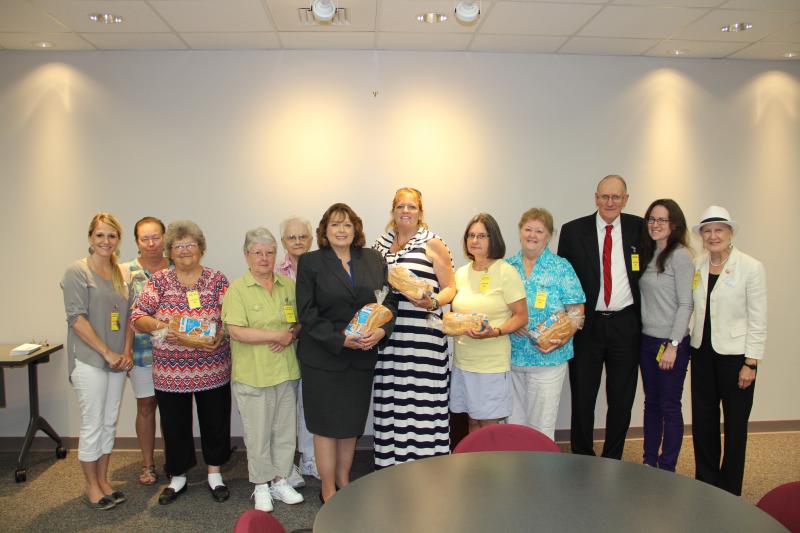 Vicki Stuart (center, dark suit, holding a loaf of bread in her arms), chair of the Maine Credit Union League’s Social Responsibility Committee, which coordinates the Maine Credit Unions’ Campaign for Ending Hunger, stands with representatives from Good Shepherd Food Bank and some of the food pantries that received contributions through the Campaign’s Share the Bread event. Courtesy photo