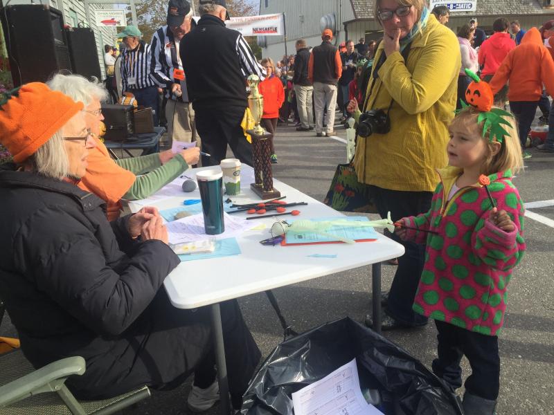 Pumpkin Derby volunteer Beth Morris of Nobleboro speaks with entrant Helen Rice, 5, of Walpole. Rice’s mother Susan Rice looks on. SUSAN JOHNS/Wiscasset Newspaper