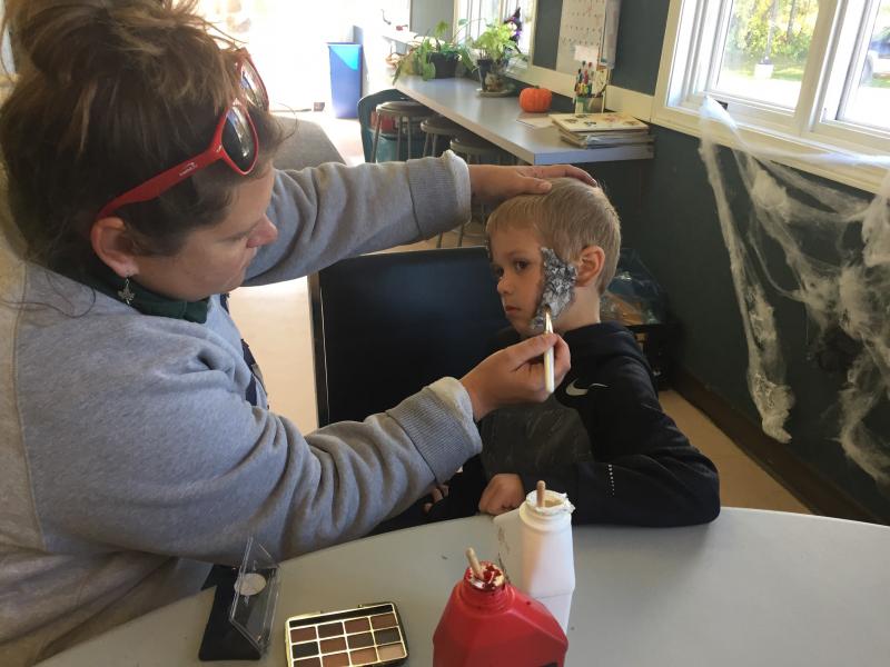 Event volunteer Amanda Gray paints zombie features onto the face of runner Paul Leeman IV, 7, of Round Pond. SUSAN JOHNS/Wiscasset Newspaper