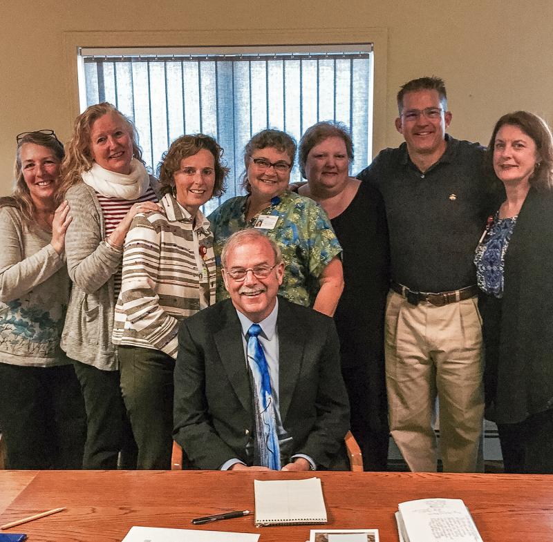 The Miles & St. Andrews Home Health & Hospice team honors Rev. Ken Dale for his work caring for terminally ill patients. From left are: Deb Talacko, RN, Kirsten Skorpen, MSW, Kathy Bean, RN, Lori Green, RN, Sandy Poland, Dr. Robert Hunold, and Connie Jones. Center: Rev. Ken Dale. Courtesy photo