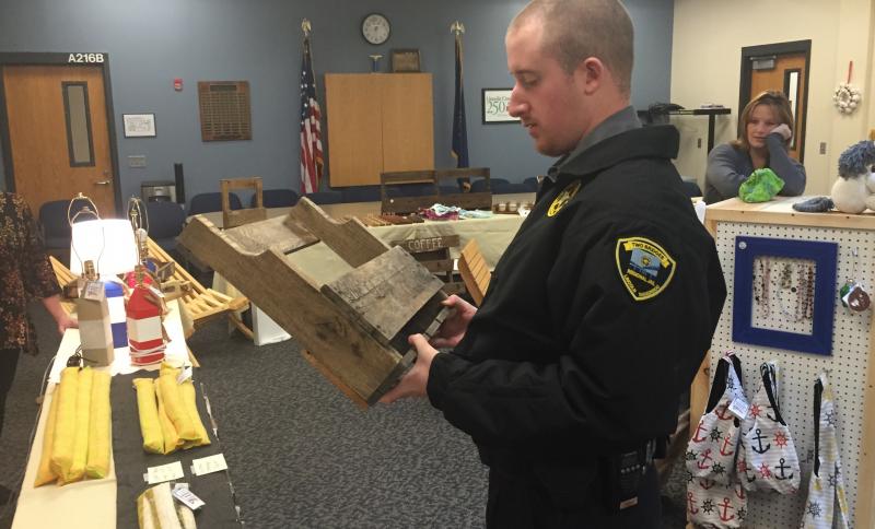 Correctional Officer Terry Marks looks over a potential Christmas gift at Two Bridges Regional Jail’s craft fair Nov. 28. SUSAN JOHNS/Wiscasset Newspaper