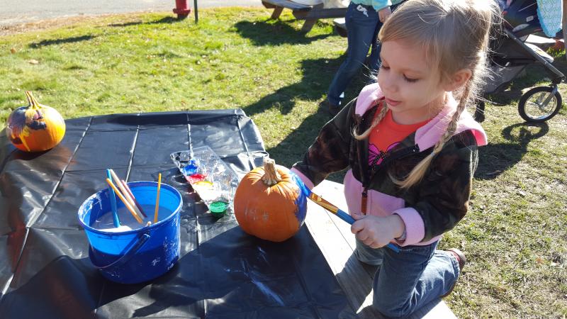 A young artist paints her pumpkin blue during the Oct. 31 Fall Harvest Fair at the Great Salt Bay Community School in Damariscotta. The money raised at the fair will be used to fund the GSB eighth grade class trip to Boston in the spring. BEN BULKELEY/Wiscasset Newspaper
