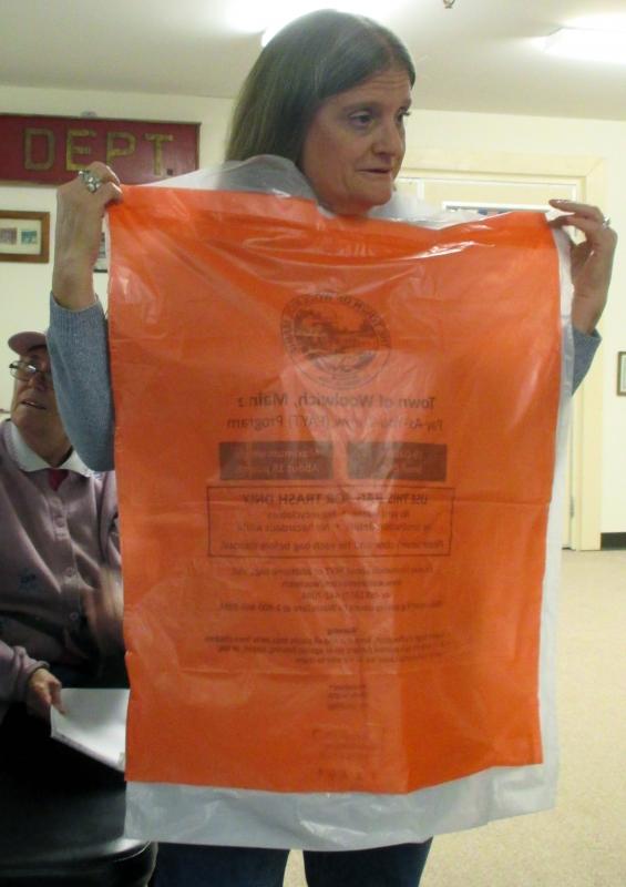 At a Woolwich hearing in October, Sue Ellen Whittaker holds two trash bags to show selectmen that the pay-as-you-throw bag is smaller. File photo