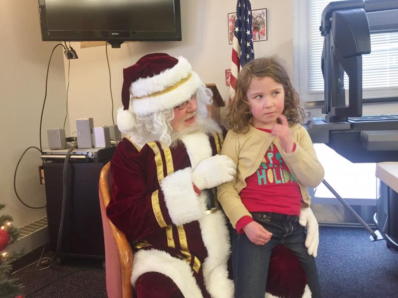 Adeline Magenis, 5, of Brunswick ponders a question from Santa. SUSAN JOHNS/Wiscasset Newspaper