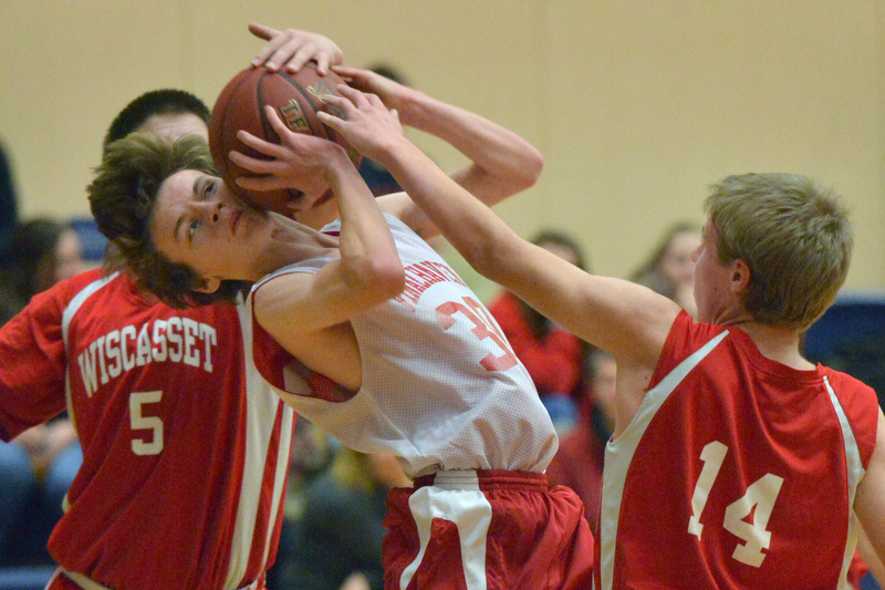 Vinalhaven’s Tim Farrelly, center, gets the worst of this action as he takes the ball to the side of the head as both Billy Pinkham, back, and Josh Jones got a hand on the ball. Wiscasset won the game 52-50. (Photo by Ron Hawkes)
