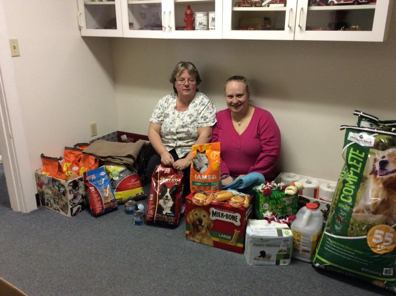Donna Gregory, left, and Amylynn Balsdon, right, surrounded by the pile of donations made to the Lincoln County Animal Shelter as part of their event. KATRINA CLARK/Boothbay Register