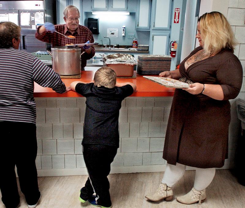 Adena Wilcox and her son, Michael, stand in line for dinner at Skowhegan’s St. Anthony’s Soup Kitchen. (Photo: Dave Leaming)