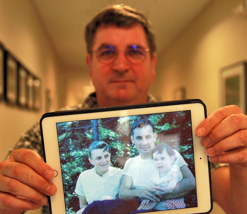 Bristol film maker Russell Lane Jr., holding a photo of his mother, father and older sister. Lane has made a movie about his parents’ role in the 1958 rescue of a boat of campers off Whitehead Island, where his father, Russell Lane Sr., was a lighthouse keeper. He will show the movie and give a short talk at Schooner Cove on Oct. 21 at 1:30 p.m. Courtesy of LincolnHealth