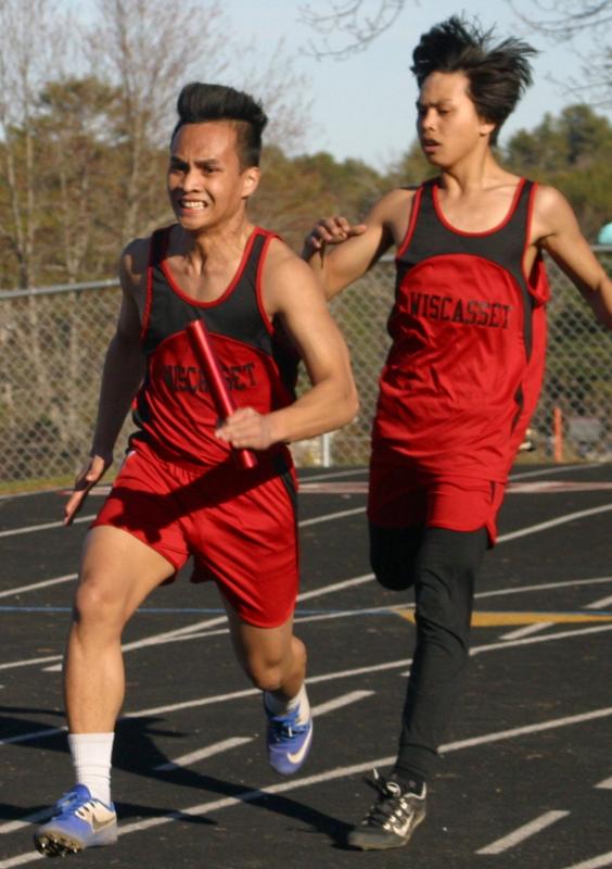 Chris Loyola takes the handoff from brother Cedrick in the 4x100-meter relay race won by Wiscasset. PHIL DI VECE/Wiscasset Newspaper