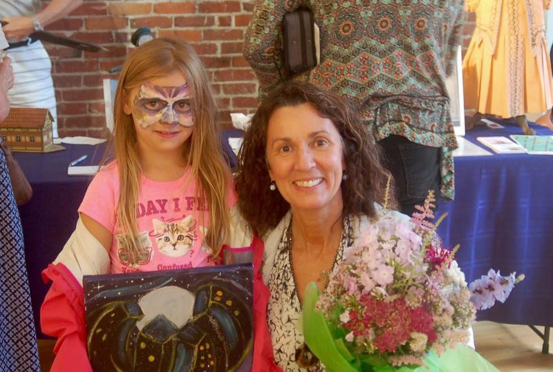 With grandmother Sherri Dunbar of Wiscasset, Natalie Dunbar, 8, in face paint buys her first painting. ART MAYERS/Wiscasset Newspaper