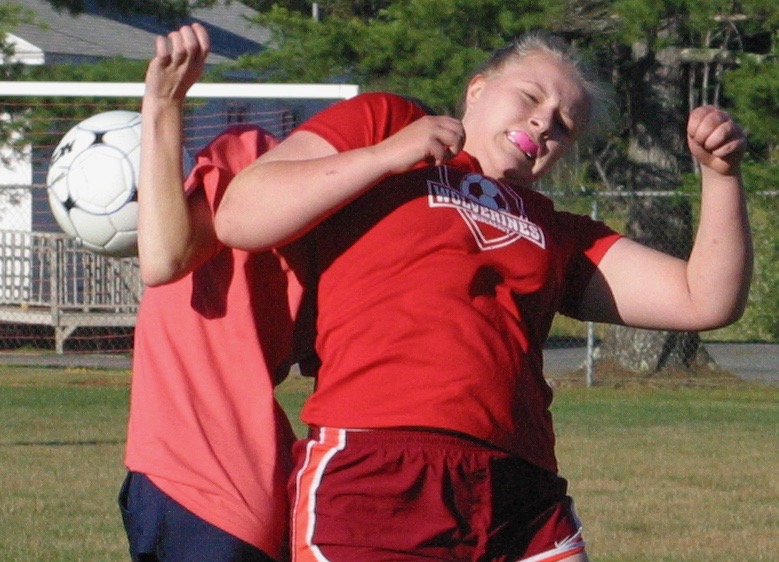 Brooke Thayer goes shoulder to shoulder with a Medomak player July 18. PHIL DI VECE/Wiscasset Newspaper
