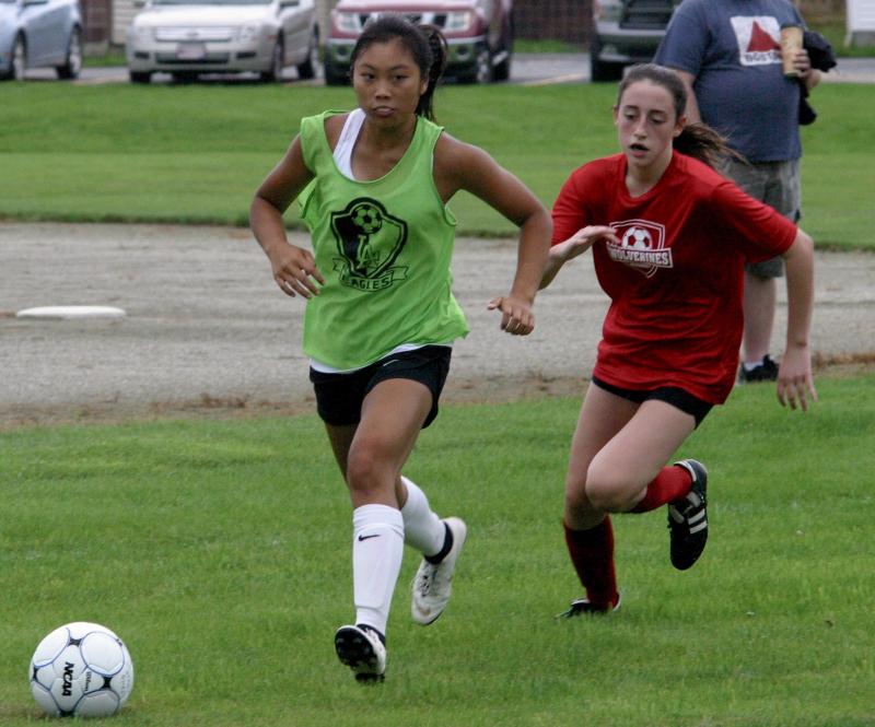 Kayla Cossette, right, runs down a Lincoln Academy player at the Richmond round robin tournament. PHIL DI VECE/Wiscasset Newspaper