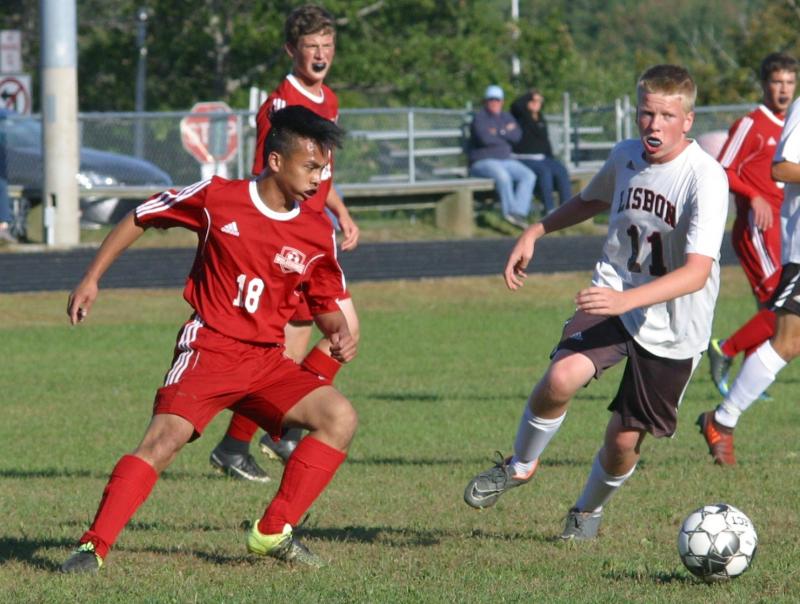 Chris Loyola #18 netted the Wolverines’ first goal. Also pictured is Lisbon’s Justin Viollette. PHIL DI VECE/Wiscasset Newspaper