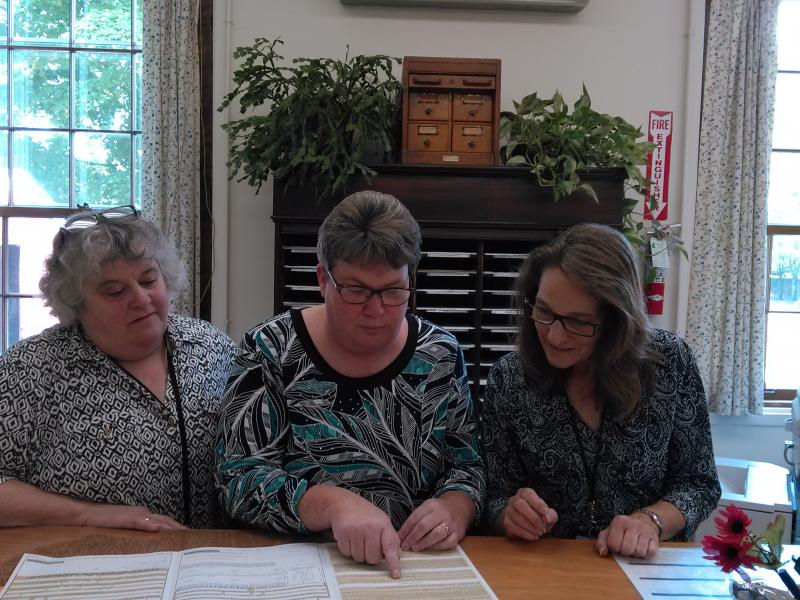 Register of Probate Catherine Moore, center, reviews passport information with Deputy Register Jeannine Clark, right, and Clerk Lisa LaPlante, left. JANE CARPENTER/Boothbay Register