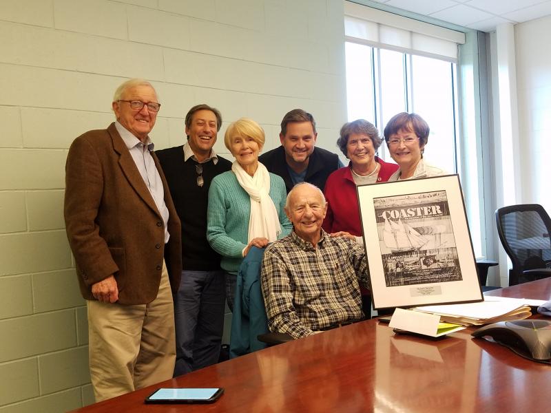 Friends of the Harbor Theater honors former President Bob Devine with a framed replica of a poster of one of the first films he brought to Harbor Theatre in 2007. Board members, from left are Ham Meserve, Eugene Molinelli, Julie Perry, Scott Larson, Helen Meserve, Robin Hall Jordan and, seated, Bob Devine. Jason Sheckley photo