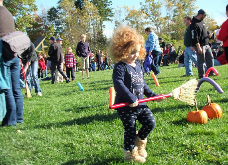 India, 2, of Portland in the Apple Broom Race, one of eight games, in the Great Pumpkin Hunt event at Coastal Maine Botanical Gardens Oct. 20. LISA KRISTOFF/Boothbay Register The Great Pumpkin Hunt at Coastal Maine Botanical Gardens Oct. 20.