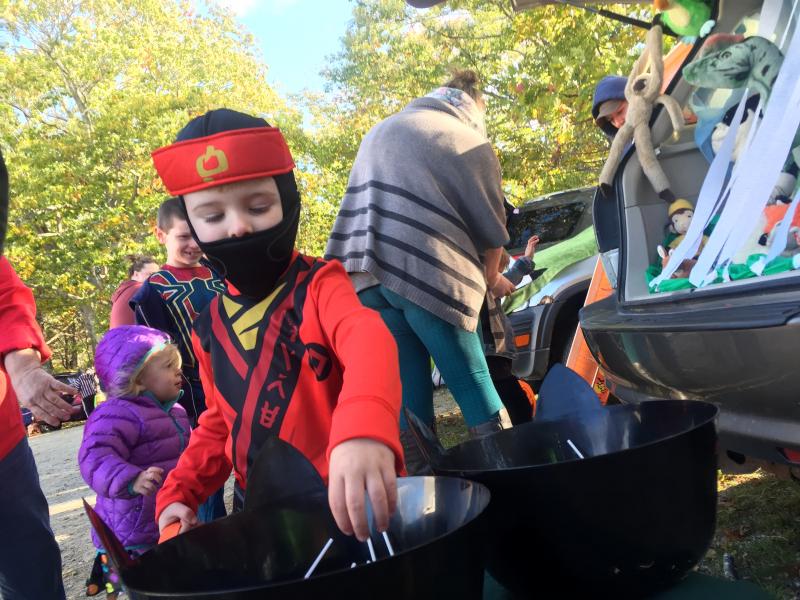 Whyatt Dutton, 4, of Gardiner reaches for treats at Huntoon Hill Grange's Trick or Trunk event Sunday, Oct. 21 in Wiscasset. SUSAN JOHNS/Wiscasset Newspaper
