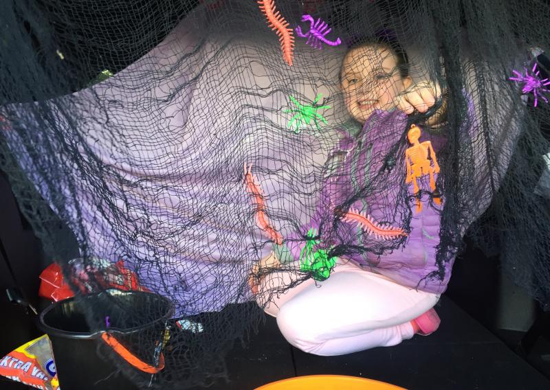 Natalie Sinclair, 7, of Wiscasset smiles behind a web-like mesh in a vehicle where she and her mother Amy Sinclair were giving out treats. SUSAN JOHNS/Wiscasset Newspaper