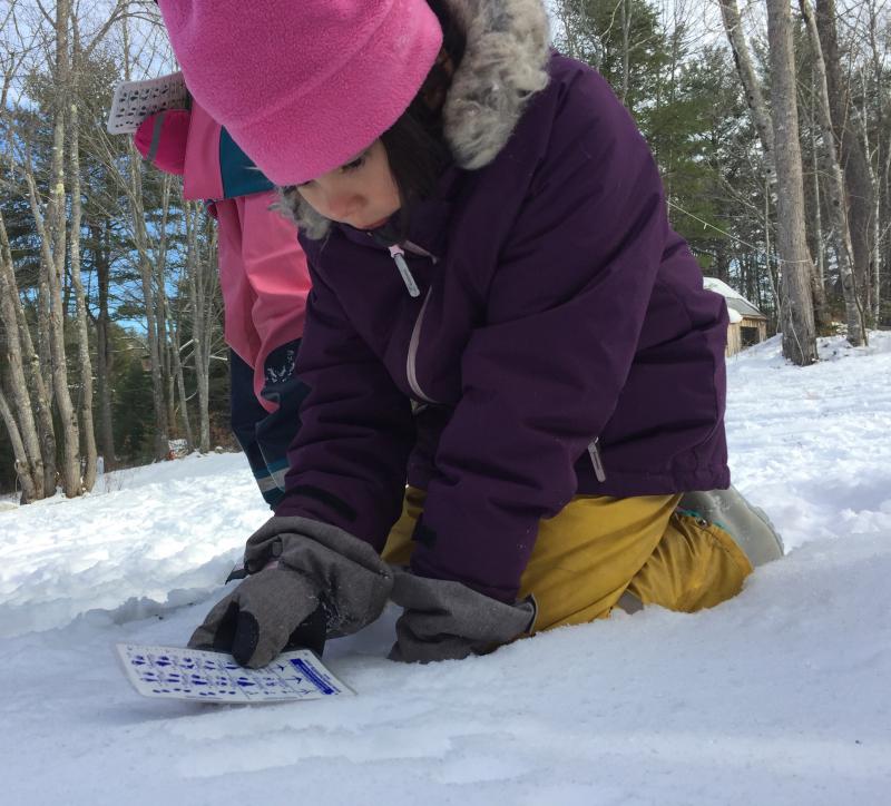 A Juniper Hill School student identifies animal tracks in the snow. Courtesy of Juniper Hill School