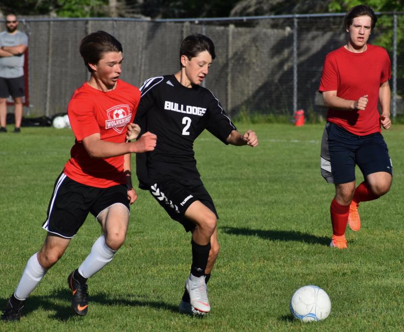 John Hodson, left, defends a Hall-Dale player. That’s Wiscasset’s Billy Pinkham lending his support. PHIL DI VECE/Wiscasset Newspaper