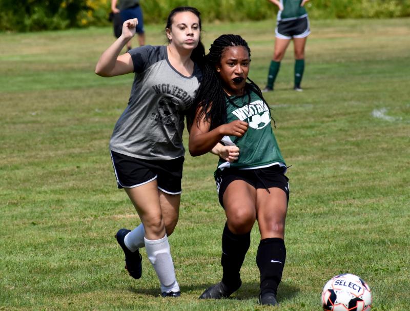 WMHS freshman Antonina Parsons goes shoulder-to-shoulder with Winthrop’s Aaliyah Wilson-Falcone. PHIL DI VECE/Wiscasset Newspaper
