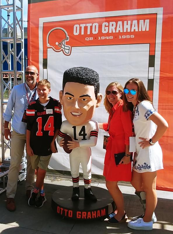 From left are Bar Clarke, Finn Harkins, Lauren Graham and Isabel Harkins stand next to the huge bobblehead of Otto Graham. Courtesy of Duey Graham