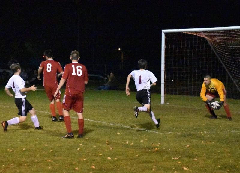 L J Travis scoops up a shot off the foot of Buckfield’s Zach Shield, #4. PHIL DI VECE/Wiscasset Newspaper