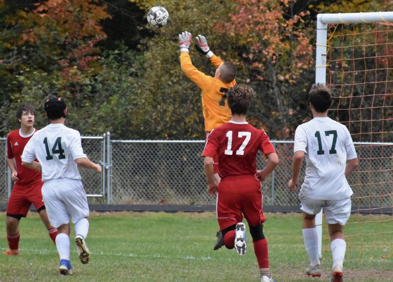 Goalie L J Travis leaps for a Spruce Mountain shot. Also shown are Wolverines Bill Pinkham, far left, and John Hodson #17. PHIL DI VECE/Wiscasset Newspaper