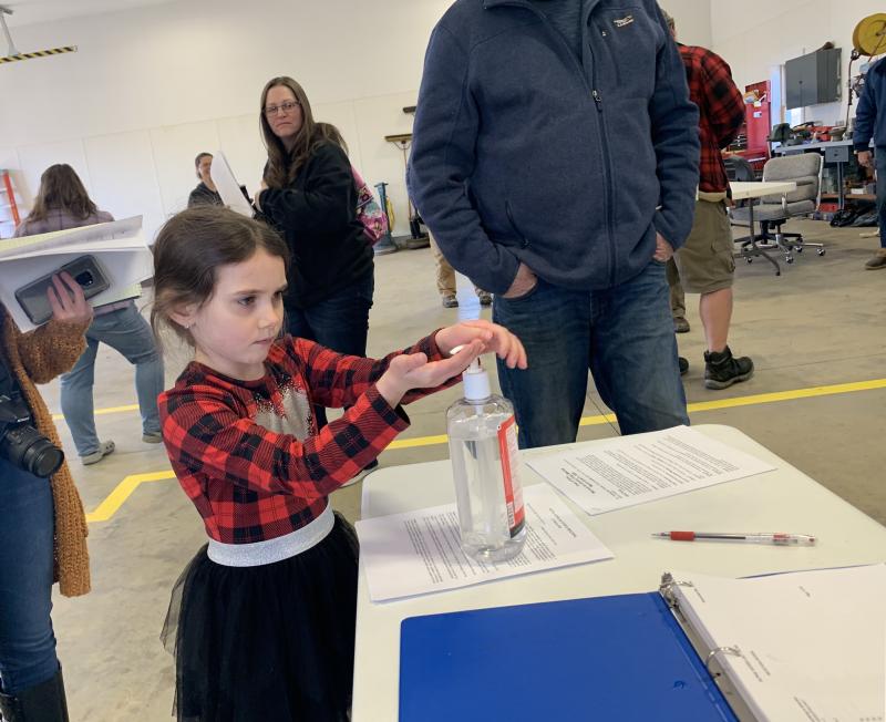 Grace Walker, 6, uses the hand sanitizer following town meeting. SUSAN JOHNS/Wiscasset Newspaper
