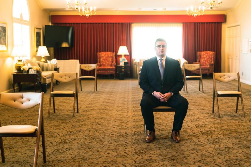 Adam Walker, funeral director at Conroy-Tully Walker Funeral Homes, is photographed in the chapel in South Portland on Tuesday, May 5. Walker created “Hugs from Home,” where funeral and wake attendees, who cannot attend in-person due to COVID-19 guidelines limiting the number of people for a gathering, can send notes that are attached to balloons on the day of the wake or funeral. (Photo by Yoon S. Byun)
